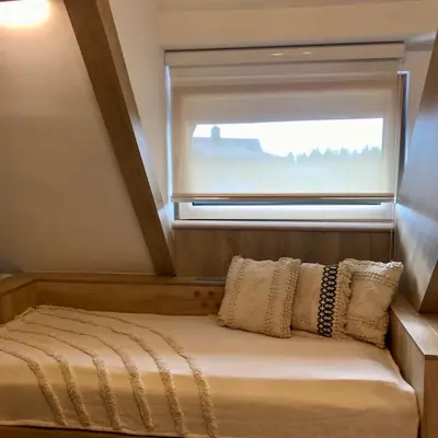 a bed in a small room with a window at NevSki Apartments in Kopaonik
