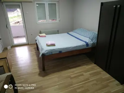 a small bed in a room with a wooden floor at Sweet home B in Niš