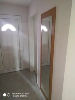 an empty room with two doors and a mirror at Sweet home B in Niš