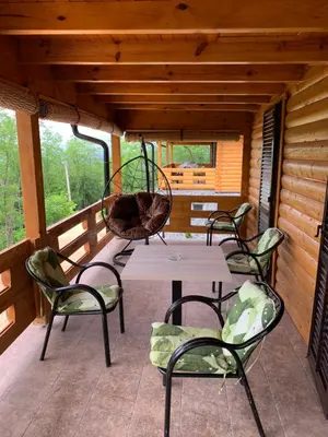 a patio with a table and chairs on a porch at Boja zalaska - drveni apartman in Jagodina