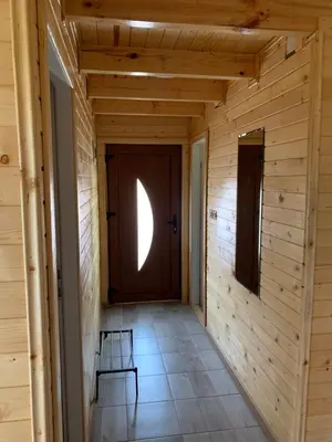 a hallway with a wooden door and two chairs at Boja zalaska - drveni apartman in Jagodina