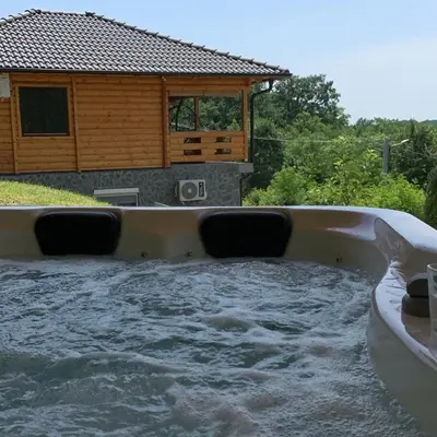 a pool of water in front of a house at Boja zalaska - drveni apartman in Jagodina