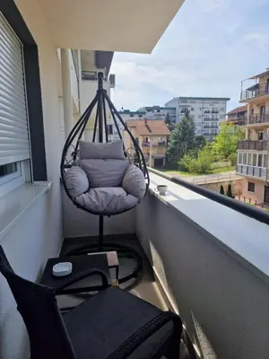 a hanging chair on a balcony with a window at Verona 25 in Vrnjačka Banja