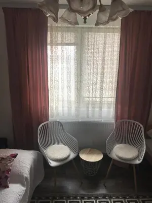 two chairs and a bed in a room with a window at Apartman i sobe Milica Vrnjacka Banja in Vrnjci