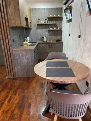 a kitchen with a wooden table and chairs in a room at 32 in Jagodina