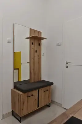 a wooden bench in a room with a mirror at 4-teen in Jagodina