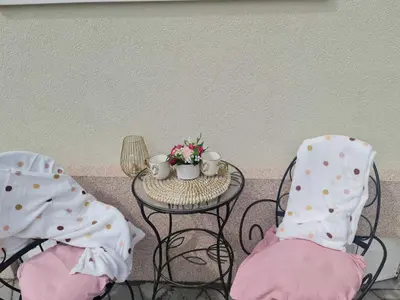 two chairs and a table with cups and flowers on it at 4-teen in Jagodina