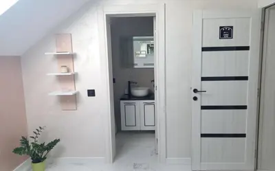 a bathroom with a white door and a sink at Pansion Eden in Niš