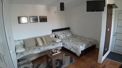 a living room with a couch and a television at Studio 