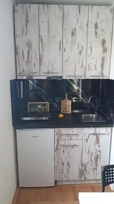 a kitchen with white cabinets and a sink at Studio 