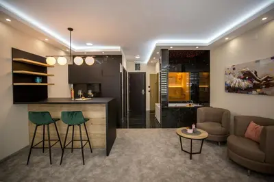 a kitchen and living room with a bar and a couch at VS Exclusive Luxury Wellness & Spa Apartmani - Vrnjačka Banja in Vrnjačka Banja