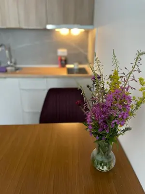 a vase of purple flowers sitting on a wooden table at President Kop A 409 - Wellness & Spa in Kopaonik