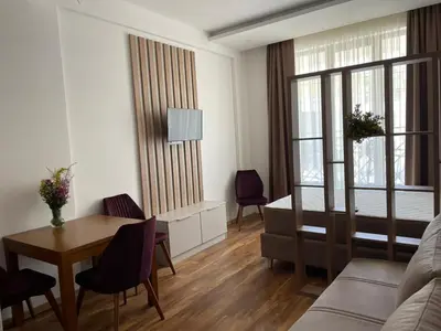 a living room with a table and a couch at President Kop A 409 - Wellness & Spa in Kopaonik