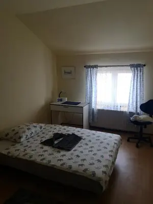 a bedroom with a bed and a desk and a window at Apartman Stanimirović in Zaječar