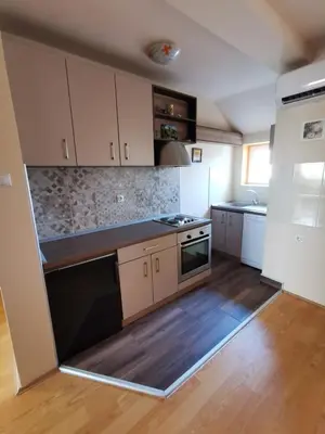 a kitchen with white cabinets and a stove top oven at Apartman Stanimirović in Zaječar