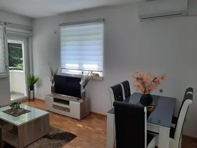 a living room with a table and a television at Apartman TEJA DELUXE in Vrnjačka Banja