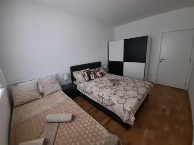 a bedroom with a bed and a couch at Apartman TEJA DELUXE in Vrnjačka Banja