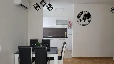 a kitchen and dining room with a table and chairs at Apartman TEJA DELUXE in Vrnjačka Banja