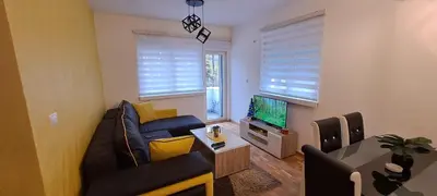 a living room with a couch and a television at Apartman TEJA DELUXE in Vrnjačka Banja