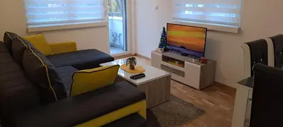 a living room with a couch and a flat screen tv at Apartman TEJA DELUXE in Vrnjačka Banja