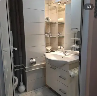 a white bathroom with a sink and a shower at Stan na dan Bor in Bor