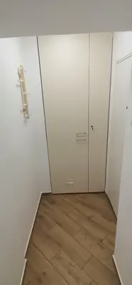 a room with white cabinets and a wooden floor at Nikolic apartment in Niš