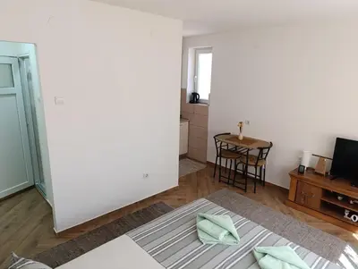 a living room with a table and a white wall at Nikolic apartment in Niš