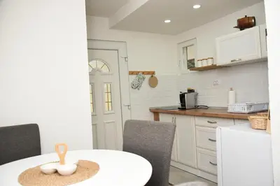 a kitchen with a white table and chairs and a counter at Vikendica Čeperković #1 in Kopaonik