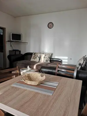 a living room with a table and a couch at Vikendica Čeperković #1 in Kopaonik