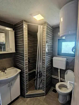 a bathroom with a toilet and a sink and a shower at Vikendica Čeperković #2 in Kopaonik