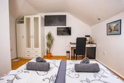 a room with a bed and a desk and a chair at Paris Night Private Parking in Niš