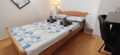 a bedroom with a bed with a blue and white comforter at Paris Night Private Parking in Niš