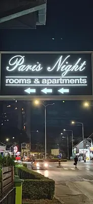 a sign for a marinamite rooms and apartments at night at Paris Night Private Parking in Niš
