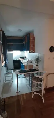 a kitchen with a table and chairs in a room at Paris 2 Night Private Parking in Niš
