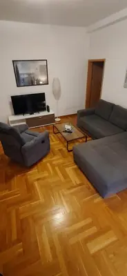 a living room with two couches and a wooden floor at Paris 2 Night Private Parking in Niš