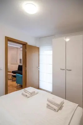 a bedroom with a bed with two towels on it at Apartmani Central 7 & Free parking in Vrnjačka Banja