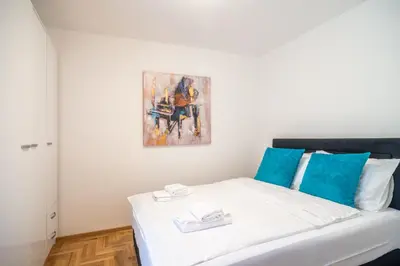 a bedroom with a bed with a painting on the wall at Apartmani Central 7 & Free parking in Vrnjačka Banja