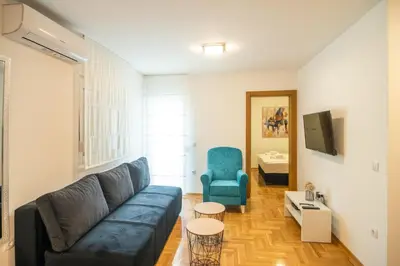 a living room with a couch and a blue chair at Apartmani Central 7 & Free parking in Vrnjačka Banja