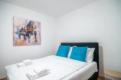 a bed in a room with a painting on the wall at Apartmani Central 7 & Free parking in Vrnjačka Banja