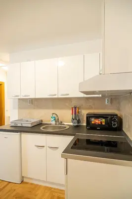 a kitchen with white cabinets and a stove top oven at Apartmani Central 7 & Free parking in Vrnjačka Banja