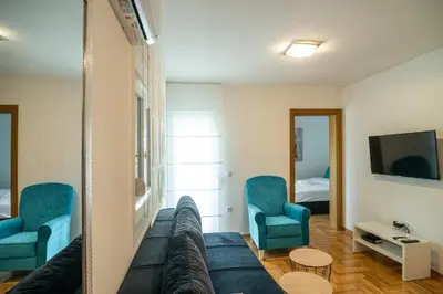 a living room with a couch and two chairs and a tv at Apartmani Central 7 & Free parking in Vrnjačka Banja