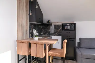 a kitchen with a wooden table and some chairs at Apartmani ZAT in Soko Banja