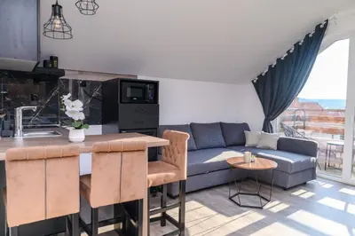a kitchen and living room with a couch and a table at Apartmani ZAT in Soko Banja