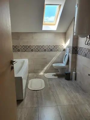 a bathroom with a tub and a toilet and a window at Apartman Buena Vista in Soko Banja