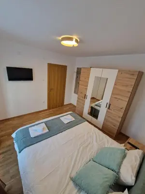 a bedroom with a large bed and a tv at Nina Apartman 2 in Soko Banja