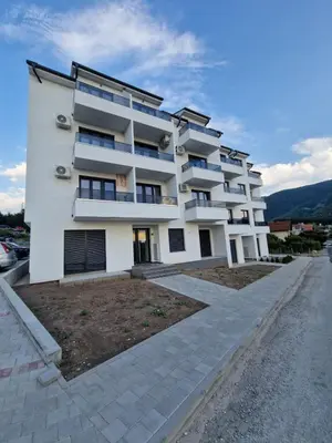 a white building with balconies on a street at Nina Apartman 2 in Soko Banja