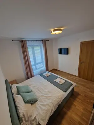 a bedroom with a bed with two pillows on it at Nina Apartman 2 in Soko Banja