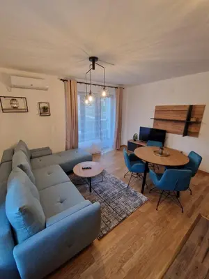 a living room with a blue couch and a table at Nina Apartman 2 in Soko Banja
