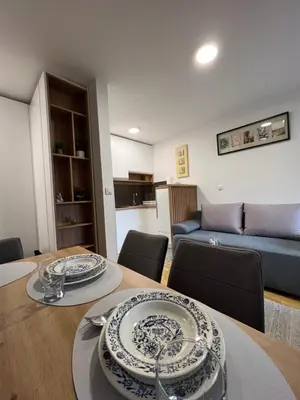 a living room with a table and a blue couch at NeNi Apartman in Vrnjačka Banja