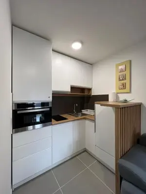 a kitchen with white cabinets and a stove top oven at NeNi Apartman in Vrnjačka Banja